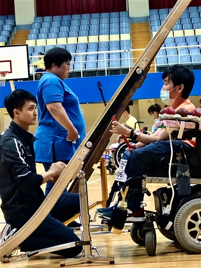 胡家榮在指導身障學員地板滾球時的專注神情