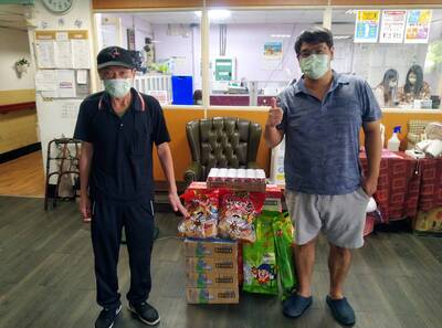大仁哥（左）日前帶了果品、餅乾、零嘴、飲料等  重返重建中心看看老友  右為新北市街友重建中心主任丁琨祥