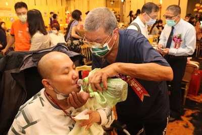 鄒茂琳拉拔罹患重度自閉症的兒子32年  即使在表揚會場仍細心照料