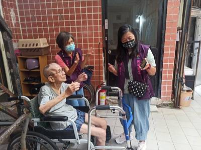 佈老志工到宅鼓勵坐輪椅的長輩伸展上肢運動