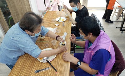 碧珠阿姨(左)與三峽國光日照中心服務對象阿翔(右)合作體驗蛋糕DIY。