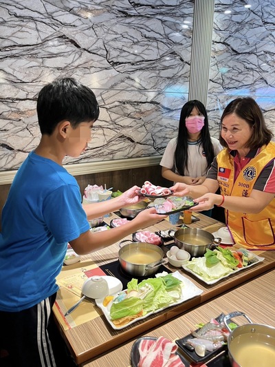 蓮新獅子會林玉玲會長(右1)遞送餐點給兒少，希望他們好好吃飽，暑假有個開心的開始。