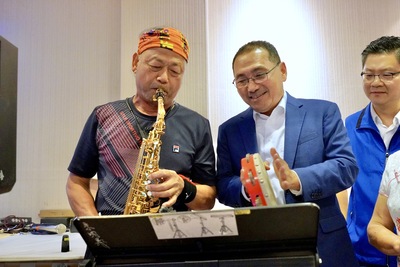 新北市長侯友宜親往道賀，朱明義邀請市長一起合奏樂曲。