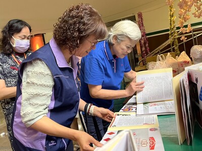 新北社會局副局長許秀能(左)與生命繪本帶領人林玉燕老師(右)翻閱生命繪本。