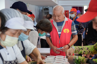 仁愛之家的范發展爺爺，幫忙行動不便的長輩領餐、協助攤位數園遊券，擔任園遊會志工樂在其中