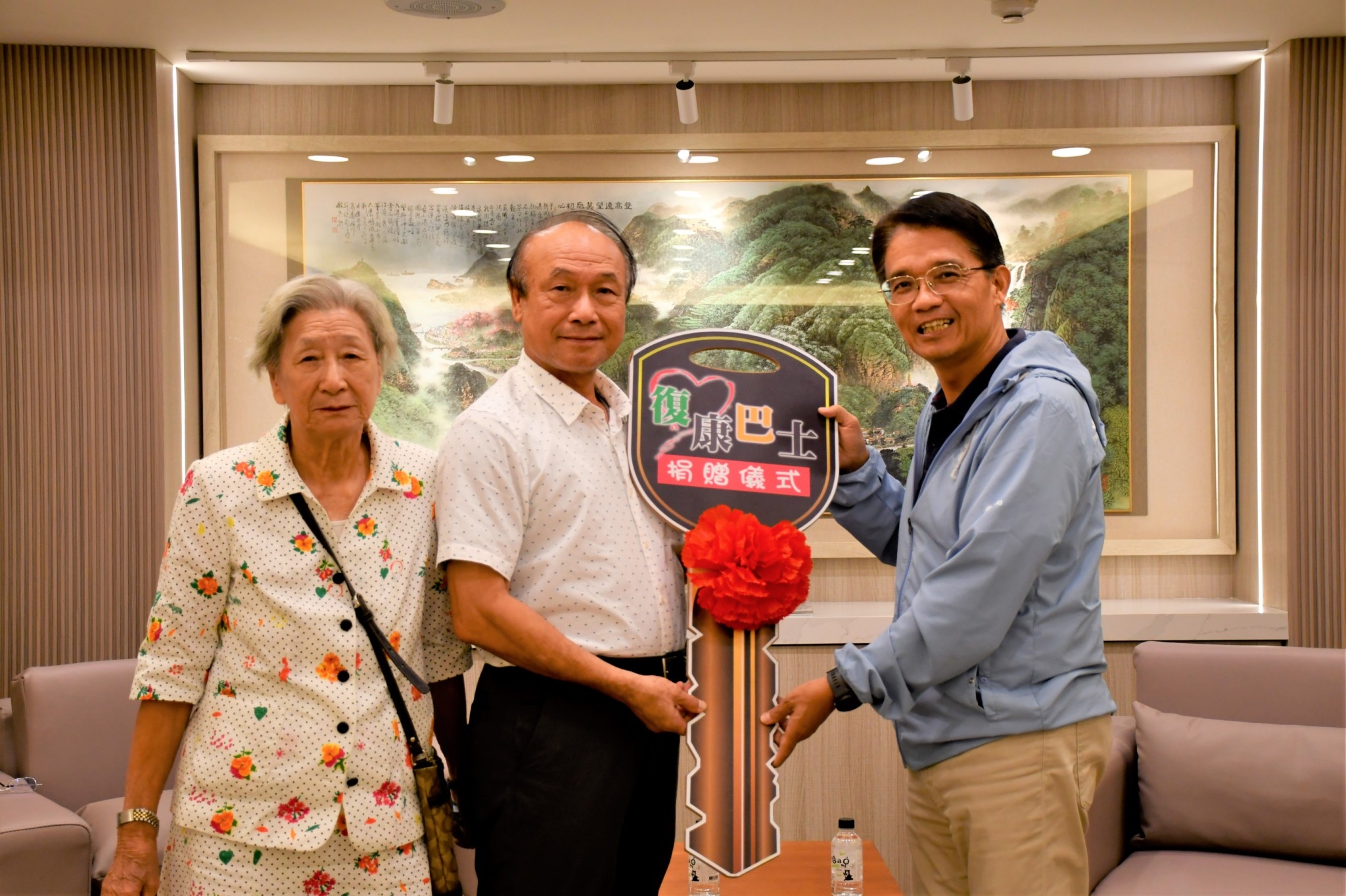 順毅紙業公司董事長陳進步(中)及其母親陳張抱(左)一起將鑰匙交給新北市府秘書長邱敬斌