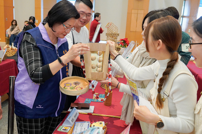 伊甸基金會早期療育服務社工，開發出珍珠奶茶造型的「啵啵遊戲杯」玩具，參賽者們向社會局長李美珍(左1)展示玩具玩法