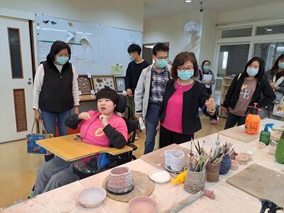  翁彥如擔任金牌解說員 為社會局長李美珍（左）等人詳細說明八里愛心教養院陶藝教室的作業情形