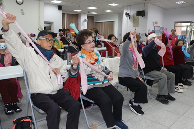 今年90歲的郭承基（左1）參加共餐已有10年 在共餐前跟著動健康老師帶領用彈力帶運動