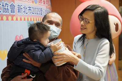  中華道家人文協會理事長張旖（右）將奶粉送給1歲的小孩