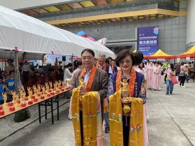  新北市議會副秘書長李政勳(左)與社會局長李美珍(右)恭迎悉達多太子法像