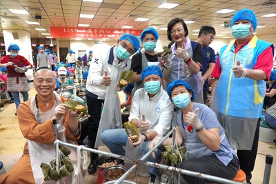 新北市副市長朱惕之(中)與元亨寺會常法師(左1)、立法委員洪孟楷(左2)、社會局長李美珍(右2)及新北市德恩慈善會理事長陳壽山(右1)等人也加入包粽行列