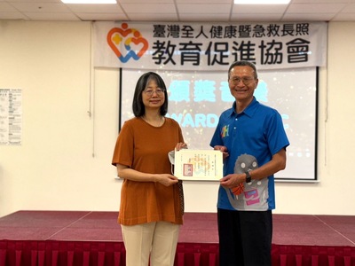  長庚大學職能治療學系副院長吳菁宜教授（左）頒發感謝狀給 東湖國小校長黃國柱 感謝學校提供場地