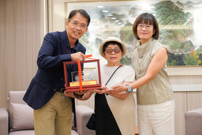 新北市府秘書長邱敬斌（左）代表侯友宜市長回贈復康巴士模型車給莊母莊呂秀惠和女兒莊瑟芬