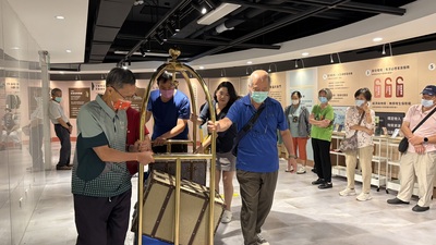  「幸福大飯店」以飯店旅程為創意核心，將抽象的身心健康化為沉浸式體驗，參加的長者推著行李車感覺準備入住飯店