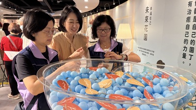 許秀能副局長（右）參與體驗 在通關後在許願池內取得祝福卡 中為揚生基金會執行長許華倚
