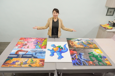  郁昕的啟蒙老師希望共好發展協會理事長呂蓮華展示郁昕的各式恐龍畫作