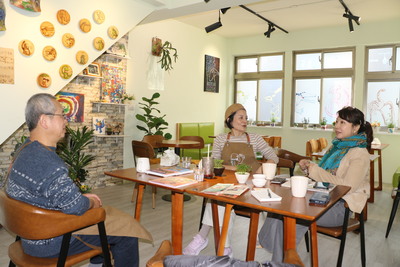  郁昕的父親郁浩華（左起）和母親施惠萍感謝啟蒙老師呂蓮華 遠處玻璃都可見恐龍畫作