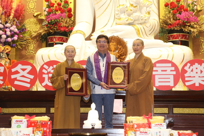  劉和然代表侯友宜市長頒贈感謝牌給覺培師父（左）和有果師父（右）