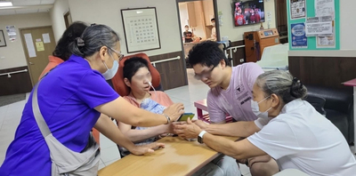 在社工和溫心天使的協助下 阿宏的母親(中)和阿宏(右2)透過手機與在機構的小瑞視訊