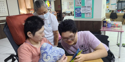 阿宏(右)將手機移近給母親(左)看弟弟小瑞的近況