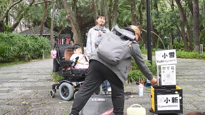 「玻璃娃娃」小雪和街頭藝人小新在台北松菸廣場開唱,遊客掏出腰包打賞。