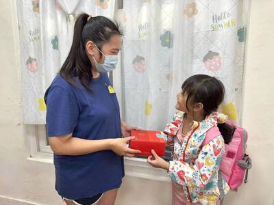  新生活課輔班老師請孩子將蛋糕帶回家送給母親