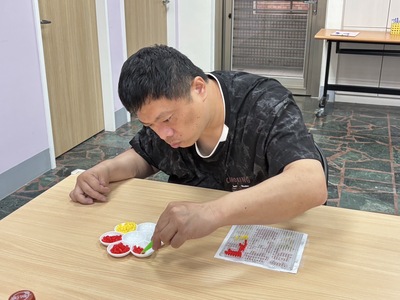  小許在樂慧中心參加「藝起動手做」，認真地拼出豆豆世界。