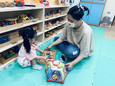中和幸福種子社區定點臨托,托育人員陪伴幼兒敲打樂器