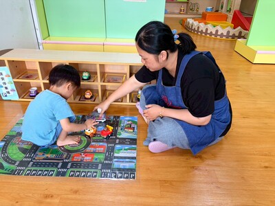 樹林保安公托中心親子館定點臨托的托育人員陪幼兒一起玩汽車