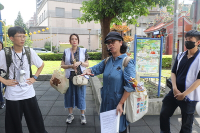  新莊社區大學講師王惠靜（右2）為兒少解說潮江寺180度轉向的典故