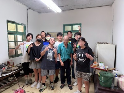 新北市少年培力園少年工班在為獨居長輩粉刷牆壁、安裝照明設備後開心地合影。