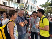 青年志工在淡水老街主動協助外國遊客  指引觀光路線  獲得外國遊客讚賞