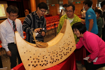 黃旭宏（左2）從達悟族的拼板小舟靈感設計了一系列的「搖曳塔塔浪」適合小孩當木馬玩  張錦麗局長（右）聽取創作者的解說