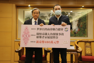 世界台灣商會聯合總會長梁輝騰（左）代表捐贈480萬元  由侯友宜代表受贈