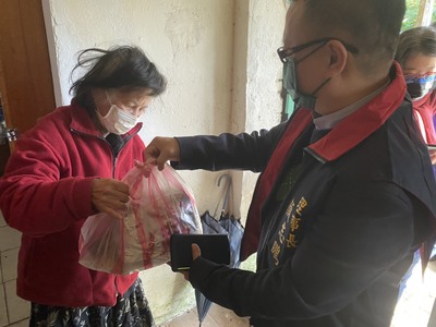 朋家建設董事長顏志鵬（右）今年春節期間跟著社工到案家送年菜