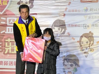財團法人新北市周可安大宗祠董事長周吉雄（左）在今年初寒冬送暖活動中送禮物給小朋友
