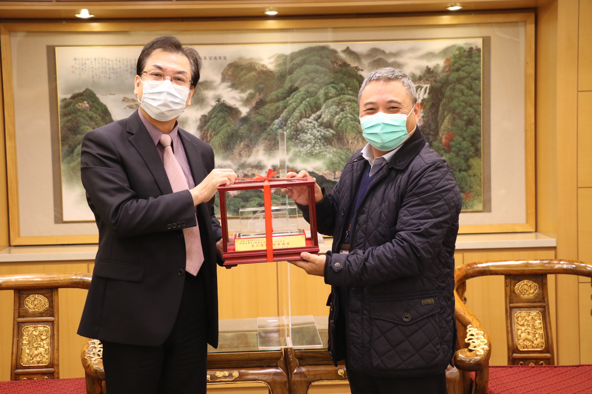 劉和然代表侯友宜市長回贈復康巴士模型車給日電貿公司副董事長李坤蒼（右）