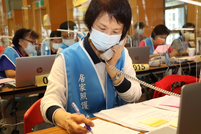 64歲的志工邱湘琦在中心忙接電話  她以師父「廣種福田、與人為善最樂！」自勉