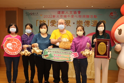 中華道家人文協會理事長張旖（右1）和社會局副局長許秀能（左1）代表捐贈粽子給黃爸爸一家人