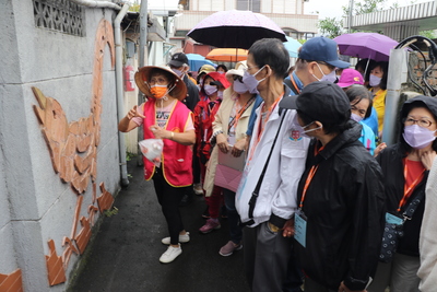 下城社區榮譽理事長賴素珍（左1）為基隆市社區幹部解說磚雕藝術台灣藍鵲