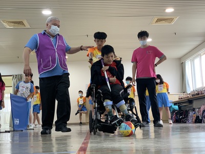 院生小純(中 )在同學協助下推輪椅曲棍球進球