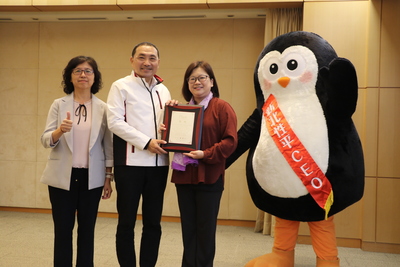 社會局副局長許秀能（左1）和兒少科長劉倩如（右1）  將榮獲行政院金馨獎的獎牌獻給侯友宜市長