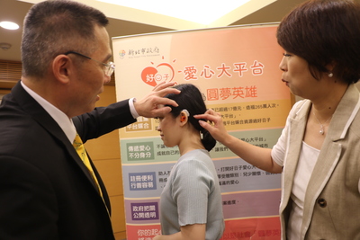 科林助聽器協理陳俊旭（左）向新北市副秘書長龔雅雯（右）說明造型係根據兒童的耳蝸利用3D列印設計製作  非常的精巧