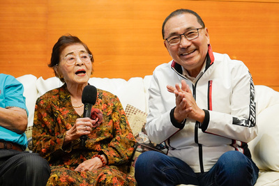 洪許俸清唱「桃太郎」兒歌,侯友宜在一旁幫忙打拍子。
